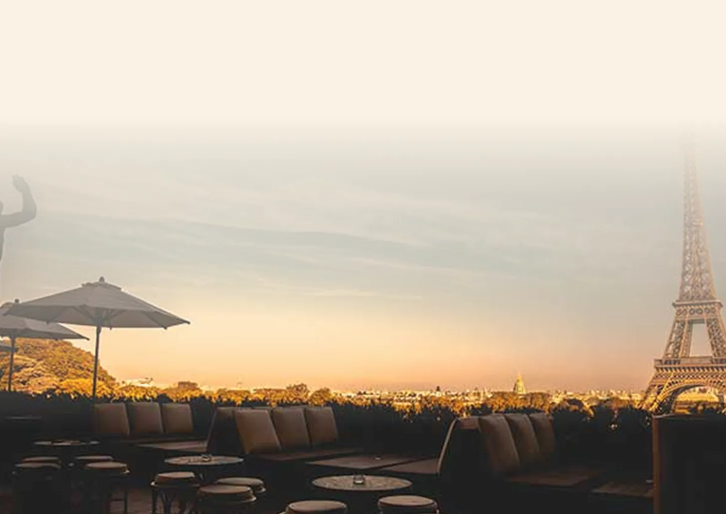 Vista de um terraço em Paris ao entardecer, com a Torre Eiffel ao fundo